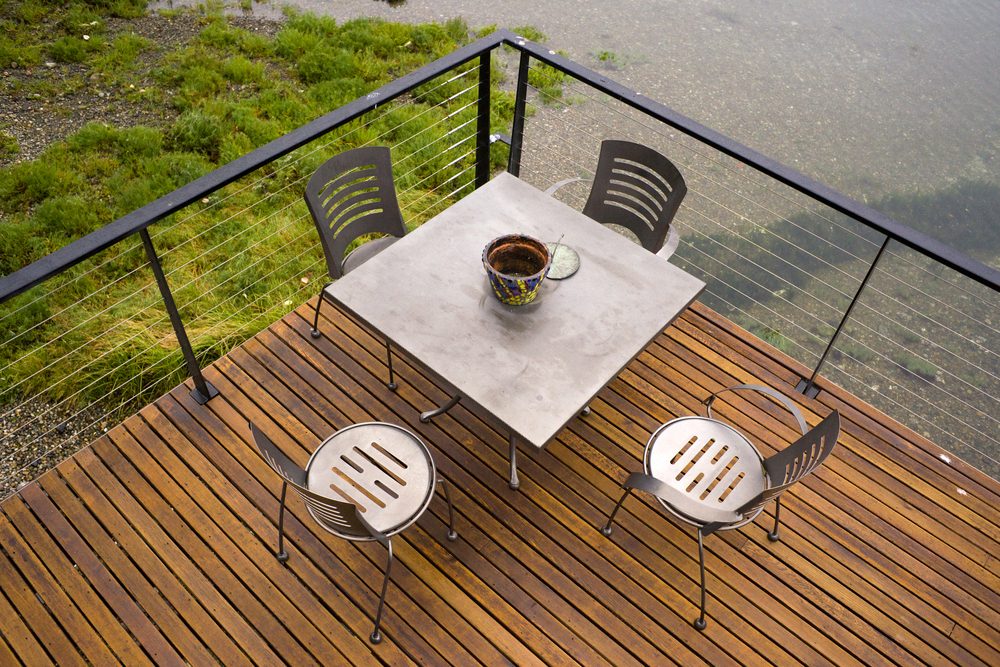 A wood deck spans out over the water metal patio furniture